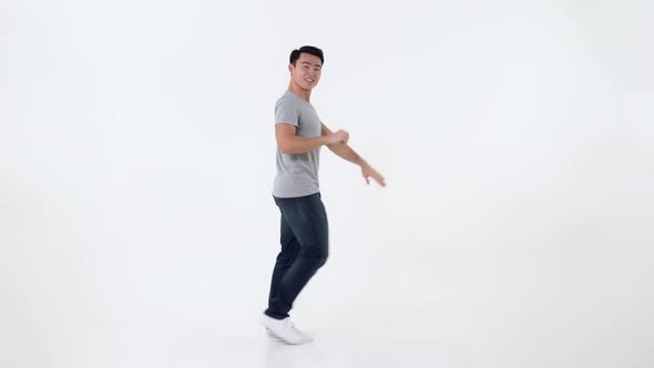 Full body of cute young happy Asian man dancing isolated on white background