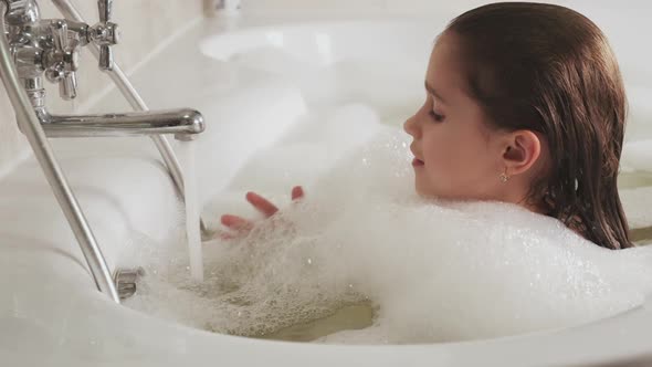 Little Beautiful Girl Bathes in a Bathtub Full of Foam alt