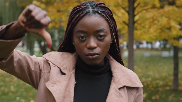 Dissatisfied Unhappy African American Frowning Female Client Showing Thumbs Down Gesture Negatively alt