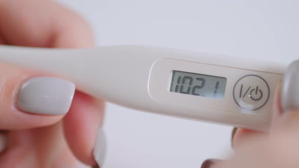 Close Up: Woman Showing Digital Medical Thermometer with High Temperature