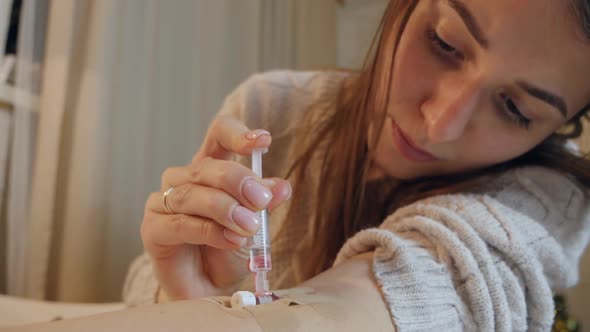 Young Woman Alone at Home Injects Medicine From a Syringe Into a Vein