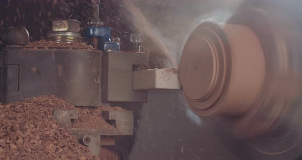 Artist creating a buddhist prayer wheel on a lathe alt