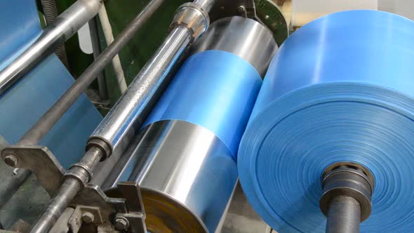 Polyethylene machine makes plastic bags in a plastic bag factory, polyethylene is wound on a bobbin alt