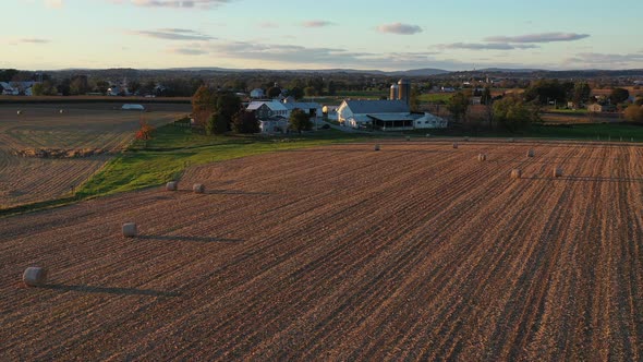 Reversal drone shot over pastures and a farmhouse that reveals a vast farmland alt