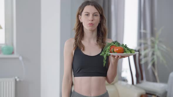 Sad Slim Woman Eating Healthful Vegan Food Sighing Looking at Camera with Upset Facial Expression alt