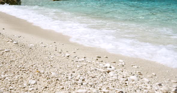 Clear Sea Foam Waves Splashing on Peaceful White Beach with Pebbles