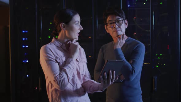 Diverse female and male it technicians using tablet checking computer server alt