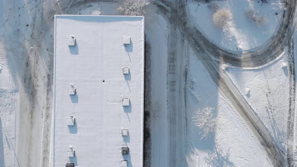 Aerial Top View Snow Covered Long Building Roof Pedestrian Road Winter Day