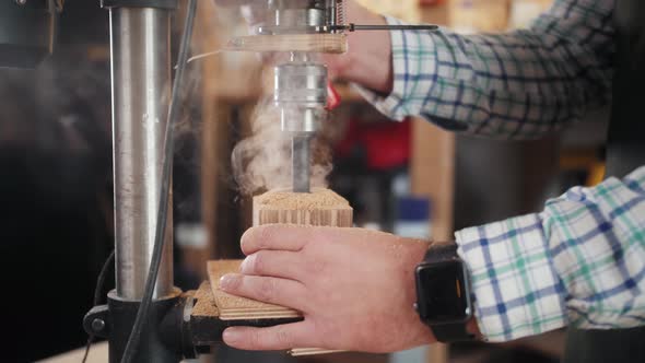 Carpenter with Drill Drilling Wooden Plank at Workshop Wood Craftsman Factory Handmade Home Business alt