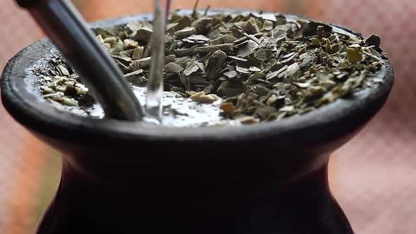 Pouring water into a "mate" gourd. Traditional Argentinian infusion. Medium closeup. alt