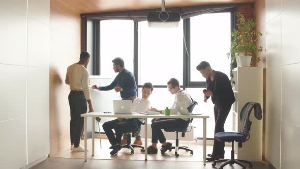Mixed Race Business Men in Open Space Office Interior with a Panoramic Window alt