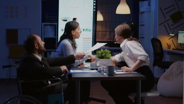 Overworked Paralyzed Disabled Entrepreneur Man in Wheelchair Sitting at Desk Overworking in Company alt