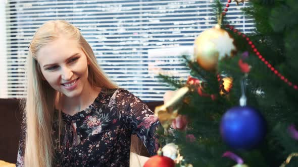 Close Up of Smiling Girl Hanging Balls on Christmas Tree