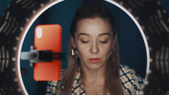 Confident Pretty Female Video Blogger Applies Lipstick in Front of Ring Light