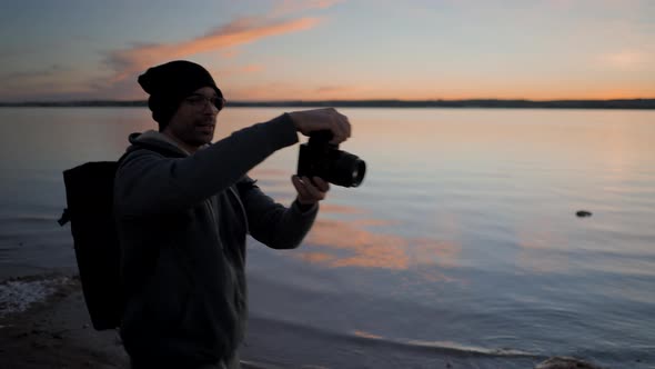Young Man Photographer Taking Pictures with a Professional Camera By the Torrevieja Pink Lake at alt