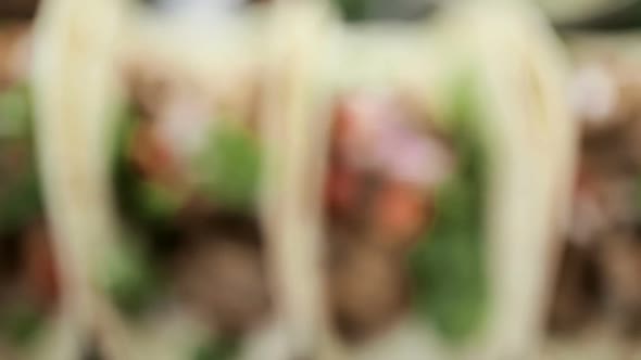 Close up of pulled pork carnitas with pico de gallo on a flour tortilla. alt