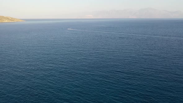 Aerial View of a Jet Ski Boat in a Deep Blue Colored Sea. Spinalonga Island, Crete, Greece