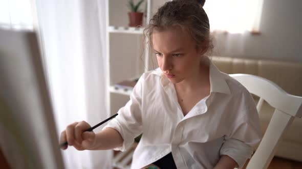 Portrait of Inspired Successful Young Artist Standing on Background of Drawing with Laptop and alt