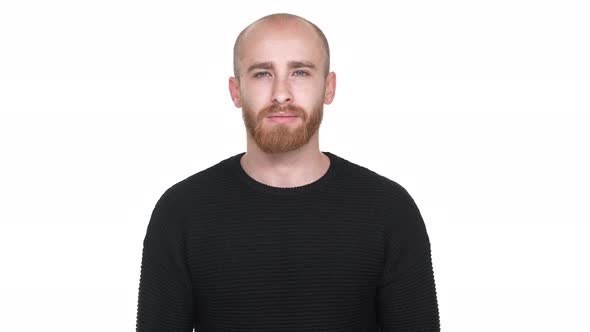 Portrait of Attractive Man 30s with Shaved Head Smiling and Squinting Being Isolated Over White alt