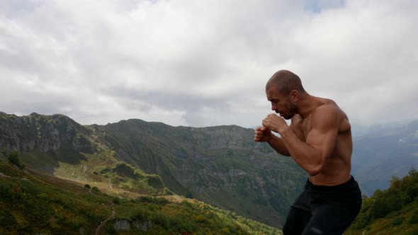 Muscular Fighter is Training Alone at Top of Mount Naked Torso Waving Hands alt