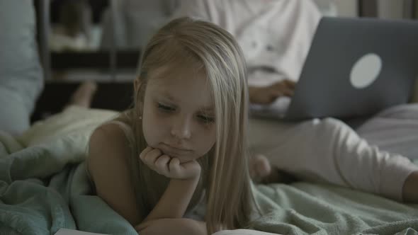 Baby Reads a Book in Pajamas