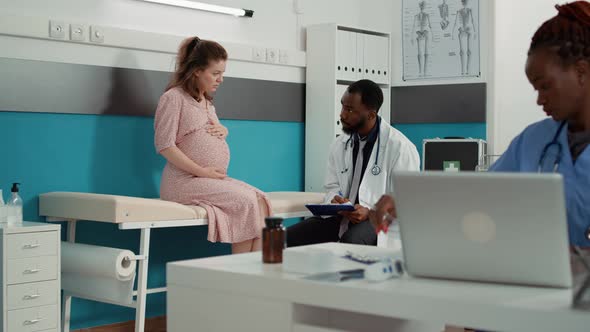 African American Medic Taking Notes at Examination with Future Mother alt
