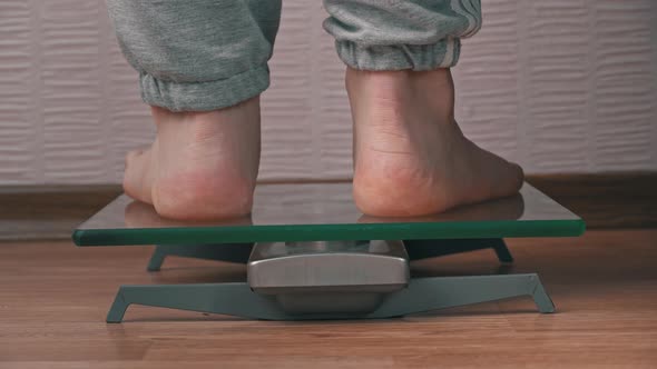 Women's Feet Stand on the Scales and Check Their Kilograms Back View alt
