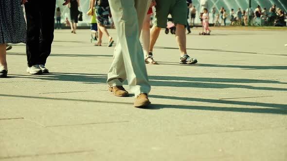 Crowd of people walking on sunny streets. 