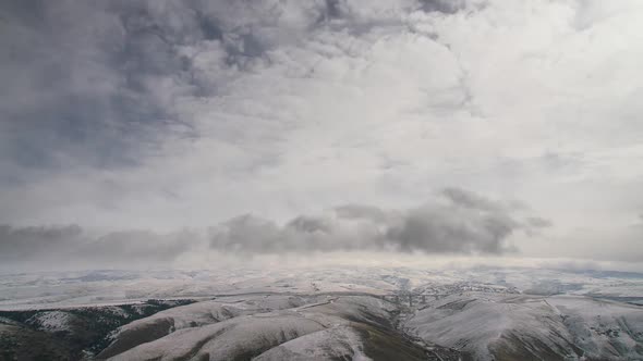 8K Cloud Movements in Patch of Snow Covered Winter Hills