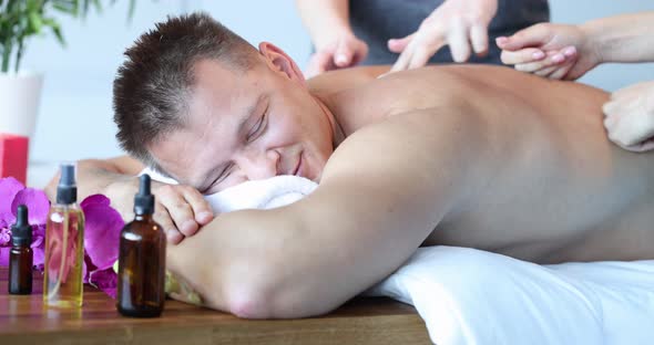 Two Women Give Back Massage to Patient in Clinic alt
