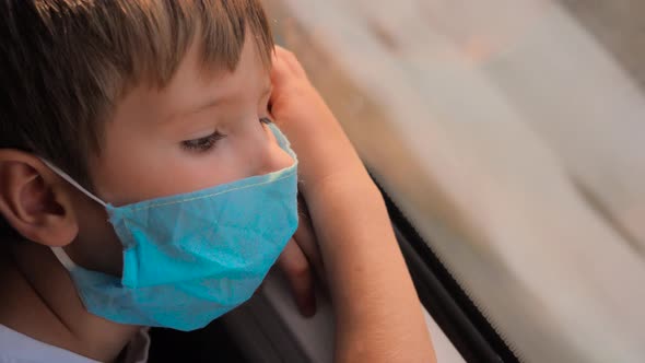 Boy Looks on Fleeting Running View From the Train Window Traveling During Pandemic Covid-19 alt