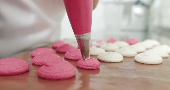 Piping Out Pink Macaron Mixture On A Slip Mat On Backing Tray Chef Making alt