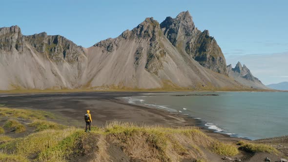 Aerial Drone Circle Movement Arount Man and Stokksnes Landscape in Iceland alt
