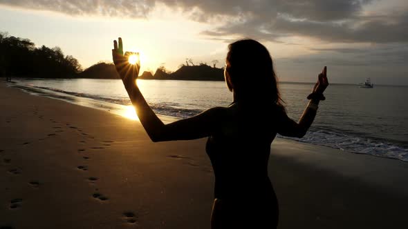 Young Girl Practicing Yoga on the Beach at Sunset