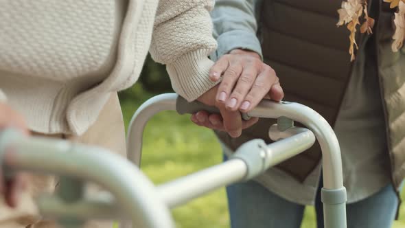 Woman Covering Male Hand on Walker alt