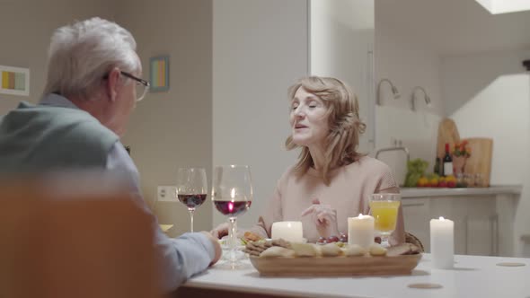 Joyous Elderly Couple Talking at Romantic Dinner alt