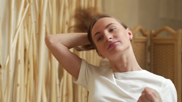 Young Woman Checking Her Hair in Bathroom Mirror alt