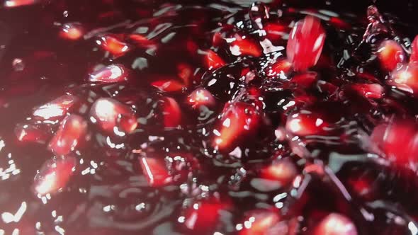 Closeup of Pomegranate Grains Falling in the Red Juice alt