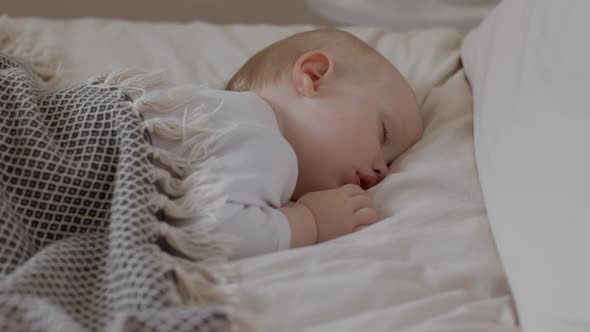 Cute Baby Boy Sleeping at Night and Making Fun Sucking Movements with Lips