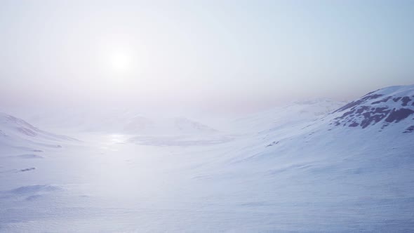 Aerial Landscape of Snowy Mountains and Icy Shores in Antarctica alt