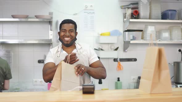 Good-looking Smiling Man Welcomes Customers alt