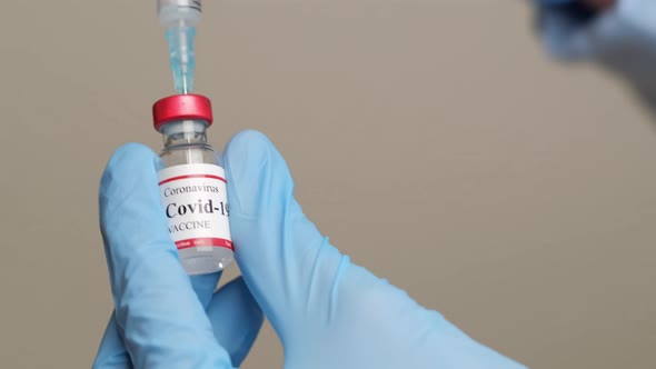 Doctor Holding Coronavirus Vaccine and Syringe to Prevent COVID19 Infection alt