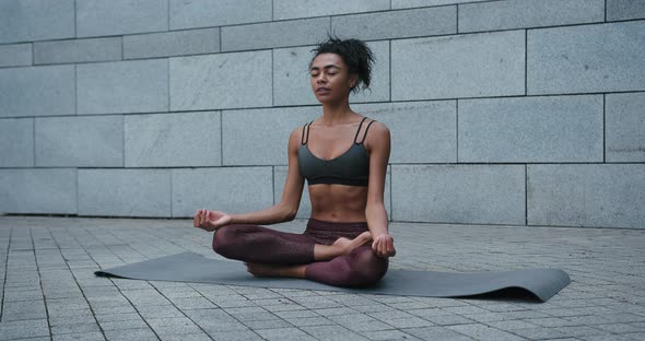 AfricanAmerican Sportswoman Does Breathing Exercises on Mat alt