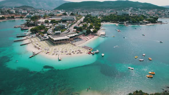 Aerial Azure Beach with Empty Sun Loungers and Boats Balkan Sea Coast Albania alt