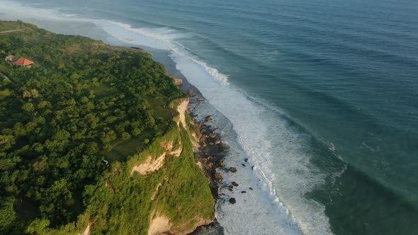 Waves break on rocky shore.  alt