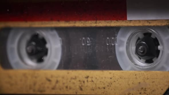 Vintage Yellow Audio Cassette Tape Rotates in Deck of an Old Tape Recorder alt