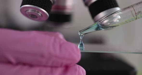Scientist Working in Biotechnology Laboratory Applies Drops of Liquid on Slide alt
