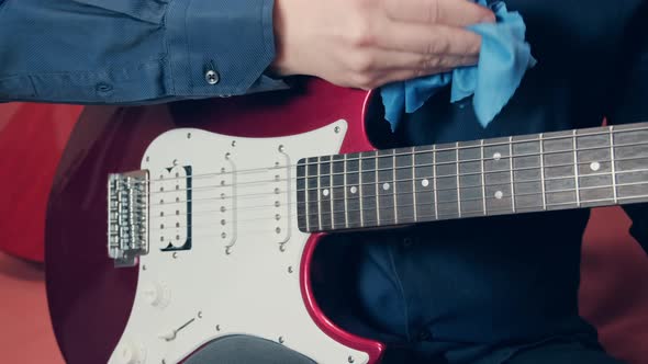 Men Hands Take Care of Electric Guitar Wiping Tool From Dust