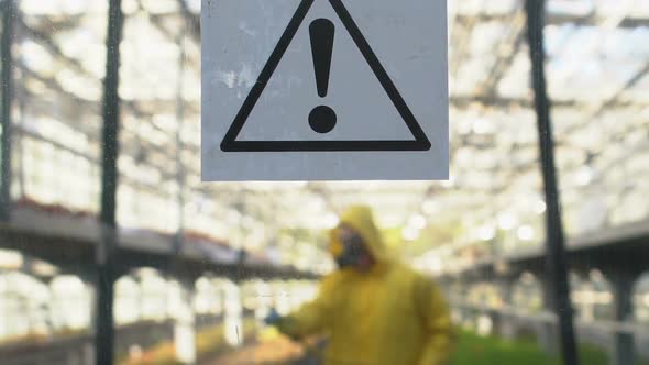 Man in Protective Uniform and Mask Spraying Chemical Liquid on Growing Plants