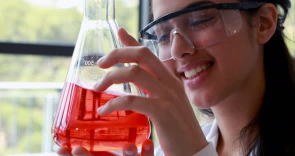 Attentive schoolgirl doing a chemical experiment in laboratory alt